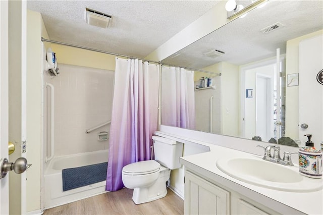 full bathroom with shower / tub combo with curtain, toilet, a textured ceiling, vanity, and hardwood / wood-style floors