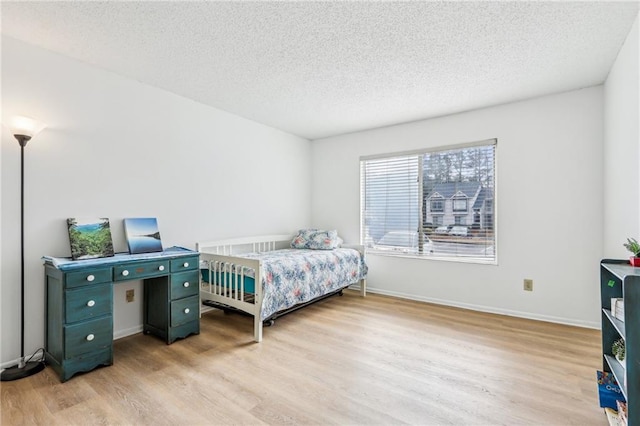 bedroom featuring a textured ceiling and light wood-type flooring