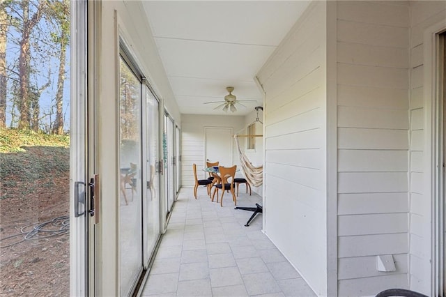 unfurnished sunroom featuring ceiling fan