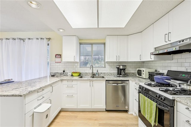 kitchen featuring white cabinetry, sink, stainless steel dishwasher, kitchen peninsula, and gas range