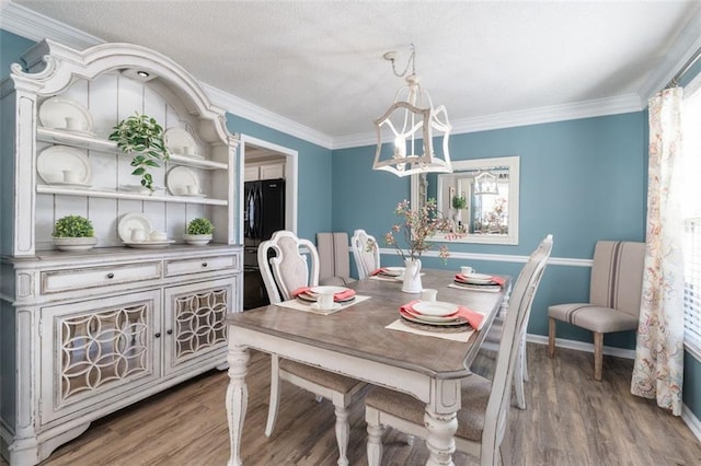 dining space featuring wood-type flooring and ornamental molding