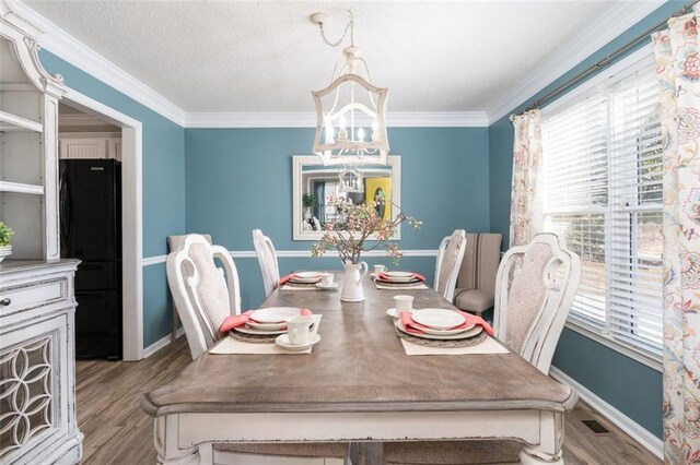 dining room with ornamental molding and light hardwood / wood-style floors