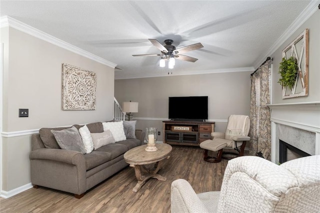 living room featuring hardwood / wood-style floors, a high end fireplace, and ornamental molding