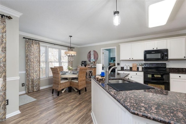 kitchen with stove, white cabinetry, pendant lighting, and crown molding