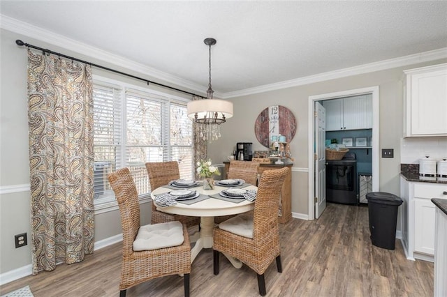 dining space featuring dark hardwood / wood-style floors, crown molding, and a chandelier