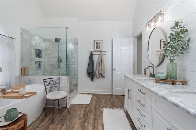 bathroom featuring vanity, vaulted ceiling, shower with separate bathtub, and hardwood / wood-style floors