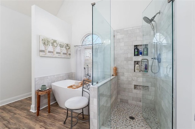 bathroom featuring plus walk in shower and hardwood / wood-style flooring