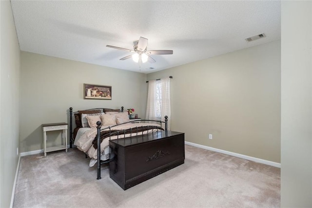 carpeted bedroom featuring a textured ceiling and ceiling fan