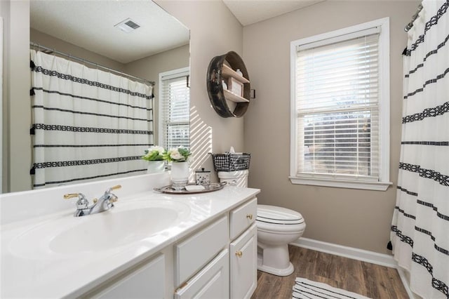 bathroom with hardwood / wood-style flooring, curtained shower, toilet, and vanity