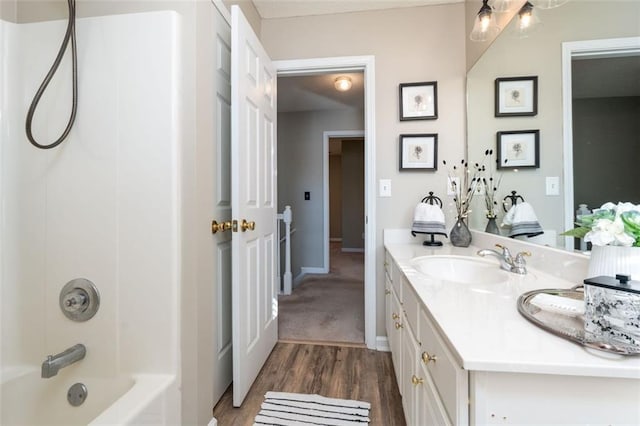 bathroom with wood-type flooring, washtub / shower combination, and vanity