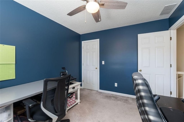 office area with a textured ceiling, ceiling fan, and light colored carpet