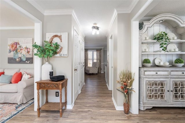 corridor with hardwood / wood-style floors and crown molding