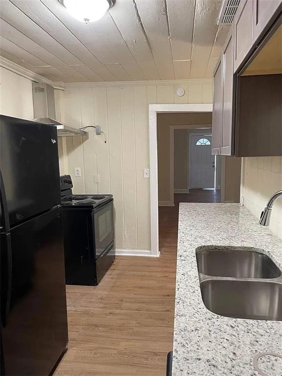 2771 Mann Rd, Winston, GA 30187 - kitchen with black appliances, light stone countertops, light wood finished floors, and ornamental molding