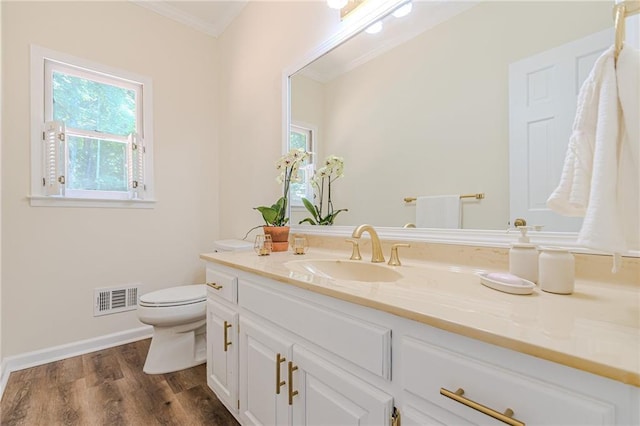 bathroom with toilet, visible vents, ornamental molding, and plenty of natural light
