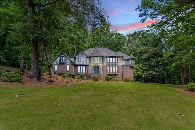 tudor house with a lawn and brick siding