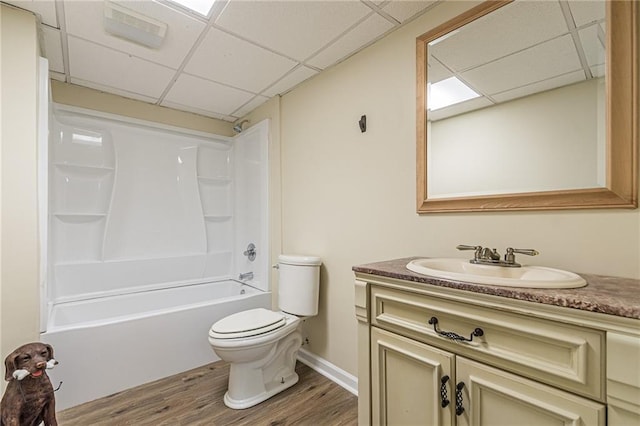 full bath with vanity, wood finished floors, toilet, washtub / shower combination, and a paneled ceiling