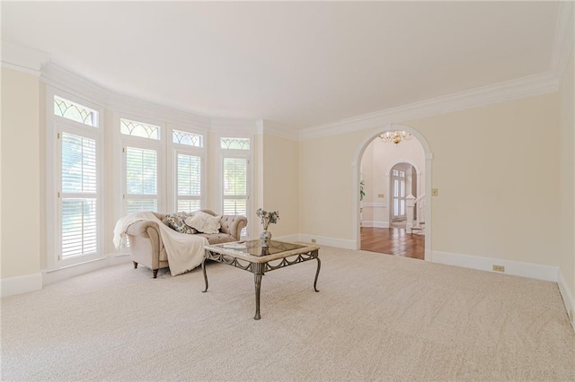 living area with arched walkways, ornamental molding, and carpet floors