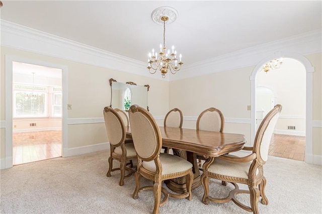 dining room featuring light colored carpet, arched walkways, and an inviting chandelier