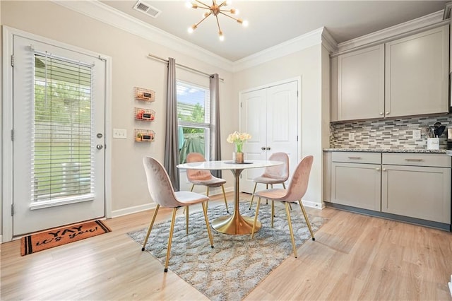 5322 Burrus Ln SW, Mableton, GA 30126 - dining room featuring light wood finished floors, crown molding, a chandelier, and baseboards