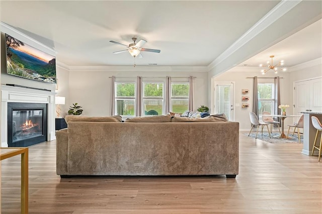 5322 Burrus Ln SW, Mableton, GA 30126 - living area featuring ornamental molding, a ceiling fan, a glass covered fireplace, light wood-style floors, and a chandelier