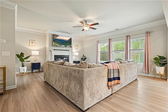 5322 Burrus Ln SW, Mableton, GA 30126 - living room with a ceiling fan, crown molding, a glass covered fireplace, light wood-style flooring, and baseboards