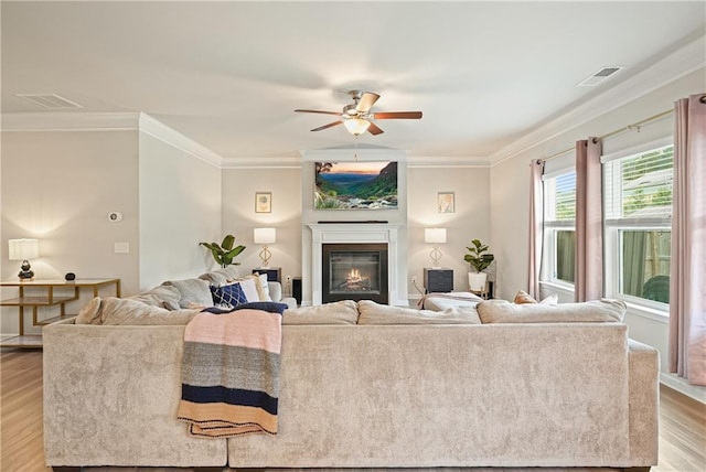 5322 Burrus Ln SW, Mableton, GA 30126 - living area featuring light wood-style floors, crown molding, a ceiling fan, and a glass covered fireplace