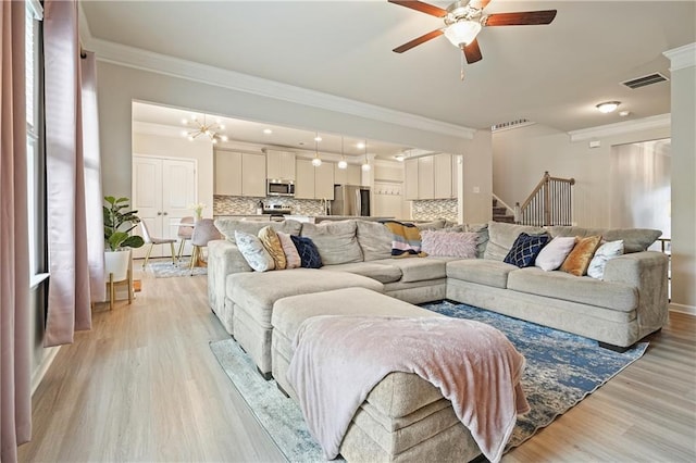 5322 Burrus Ln SW, Mableton, GA 30126 - living room with ornamental molding, ceiling fan, light wood-style flooring, stairs, and a chandelier