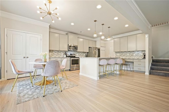 5322 Burrus Ln SW, Mableton, GA 30126 - kitchen with appliances with stainless steel finishes, ornamental molding, a breakfast bar, light wood finished floors, and tasteful backsplash