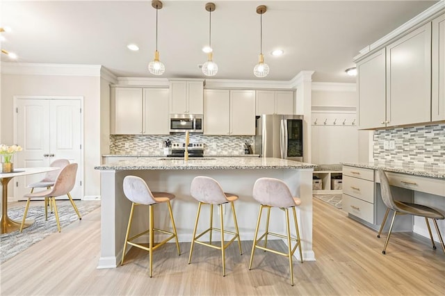 5322 Burrus Ln SW, Mableton, GA 30126 - kitchen featuring appliances with stainless steel finishes, crown molding, tasteful backsplash, light wood-style floors, and a breakfast bar area