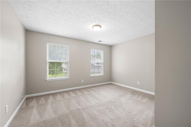 carpeted spare room featuring a textured ceiling