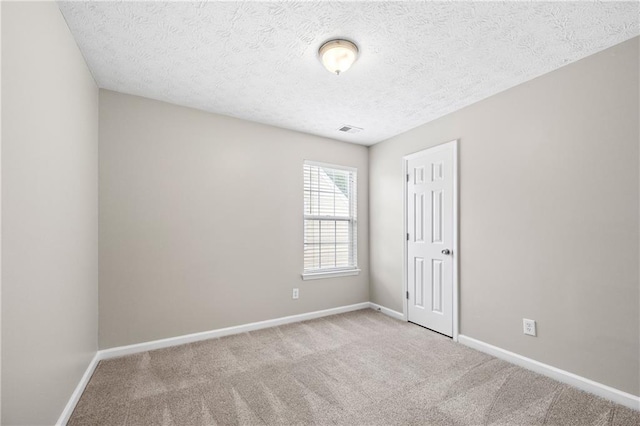 carpeted spare room with a textured ceiling