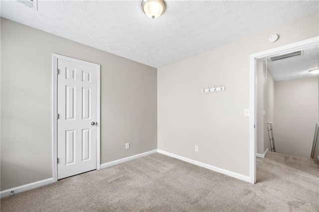 carpeted spare room with a textured ceiling