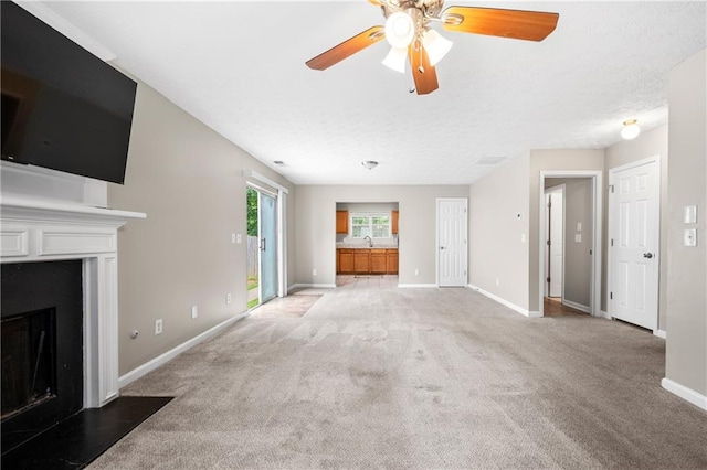 unfurnished living room with light carpet, ceiling fan, and sink