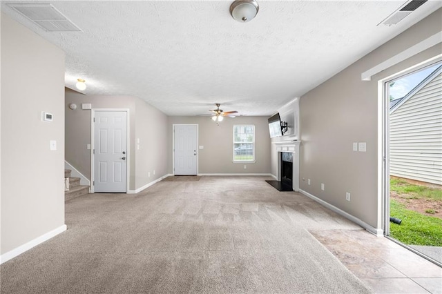 unfurnished living room with a fireplace, light carpet, a healthy amount of sunlight, and ceiling fan