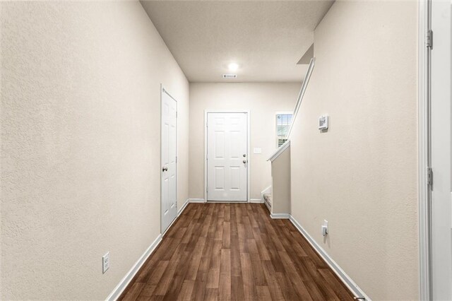 10786 Wheeler Trce, Hampton, GA 30228 - hall featuring dark wood finished floors, baseboards, stairway, and a textured wall