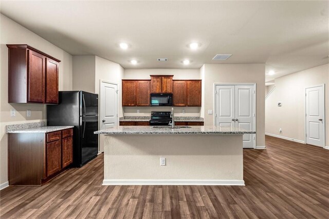 10786 Wheeler Trce, Hampton, GA 30228 - kitchen featuring black appliances, baseboards, dark wood finished floors, a kitchen island with sink, and recessed lighting