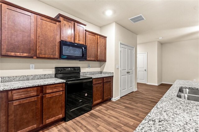 10786 Wheeler Trce, Hampton, GA 30228 - kitchen featuring black appliances, wood finished floors, baseboards, and light stone counters