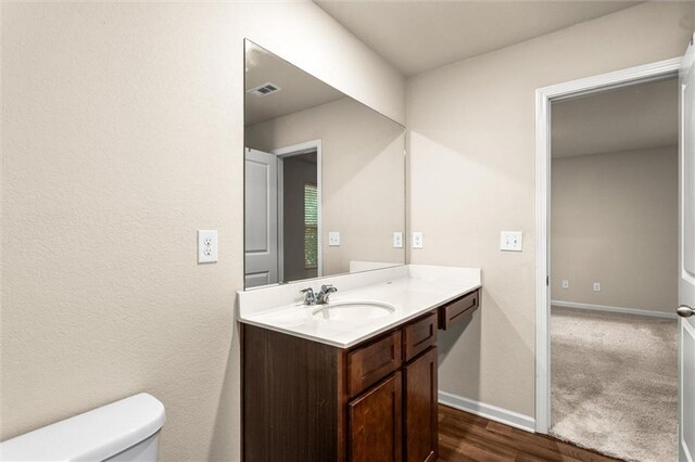 10786 Wheeler Trce, Hampton, GA 30228 - bathroom with toilet, vanity, baseboards, and wood finished floors