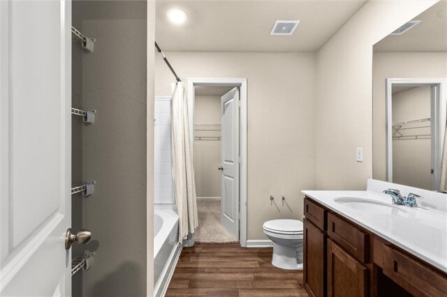 10786 Wheeler Trce, Hampton, GA 30228 - full bath featuring wood finished floors, toilet, vanity, shower / bath combo with shower curtain, and baseboards