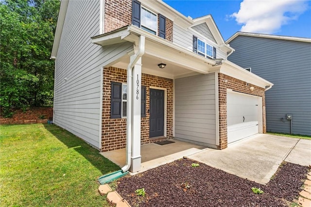 10786 Wheeler Trce, Hampton, GA 30228 - view of front of home with brick siding, a front yard, driveway, and covered porch