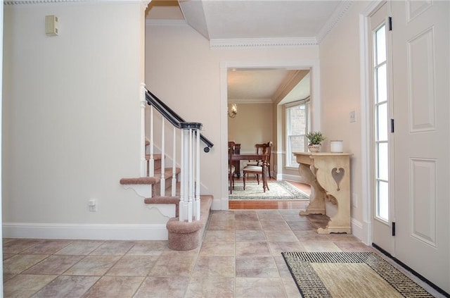entryway with baseboards, ornamental molding, and stairs