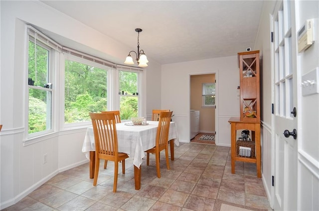 dining space with a notable chandelier, plenty of natural light, and stone finish floor