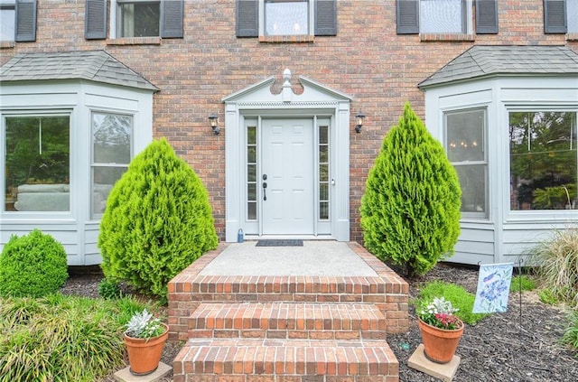 view of exterior entry featuring brick siding