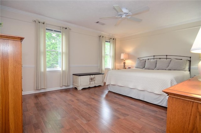 bedroom with ceiling fan, visible vents, ornamental molding, and wood finished floors