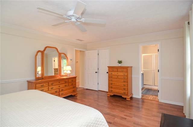 bedroom with crown molding, a ceiling fan, wood finished floors, and connected bathroom