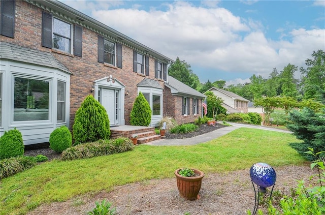 view of front of house featuring brick siding and a front yard