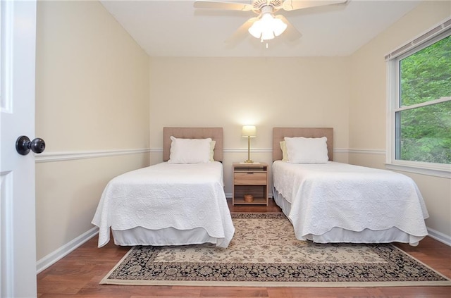 bedroom with baseboards, ceiling fan, and wood finished floors