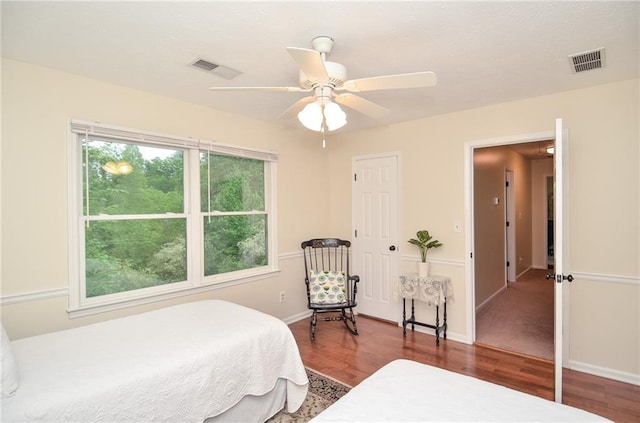 bedroom with visible vents, baseboards, ceiling fan, and wood finished floors