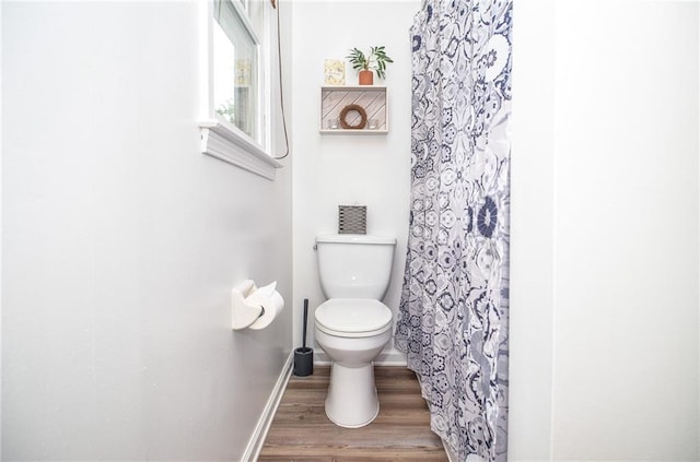 full bath with toilet, baseboards, curtained shower, and wood finished floors