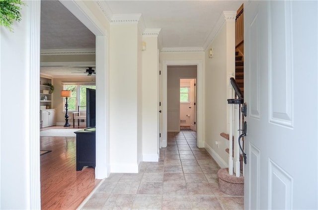 foyer entrance featuring ceiling fan, ornamental molding, and baseboards